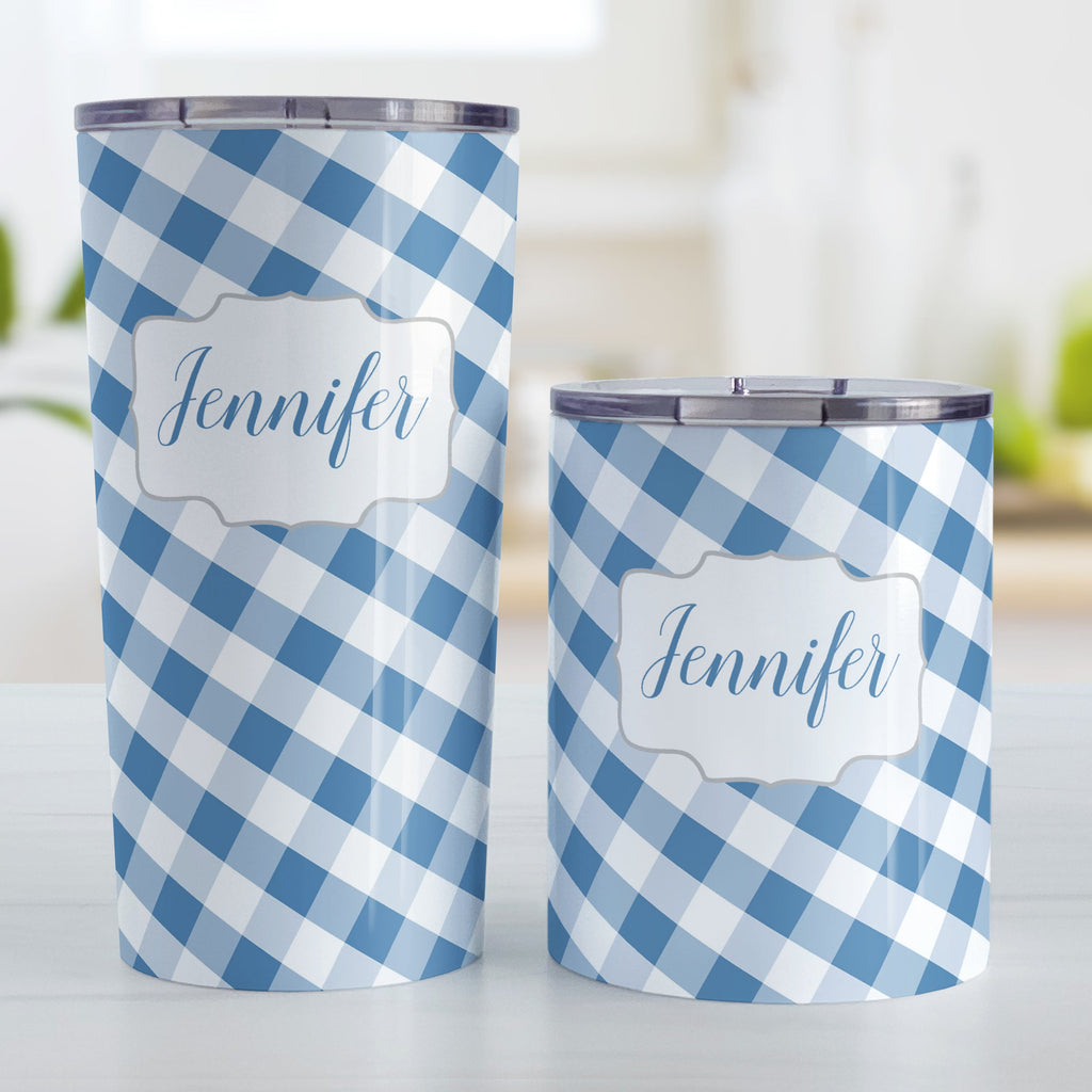 Personalized Blue Gingham Tumbler Cup (20oz and 10oz, stainless steel insulated) at Amy's Coffee Mugs. A tumbler cup designed with a slanted blue and white gingham pattern that wraps around the cup. Your personalized name is custom-printed in a blue script font in a white frame design over the gingham pattern. Photo shows both sized cups on a table next to each other.